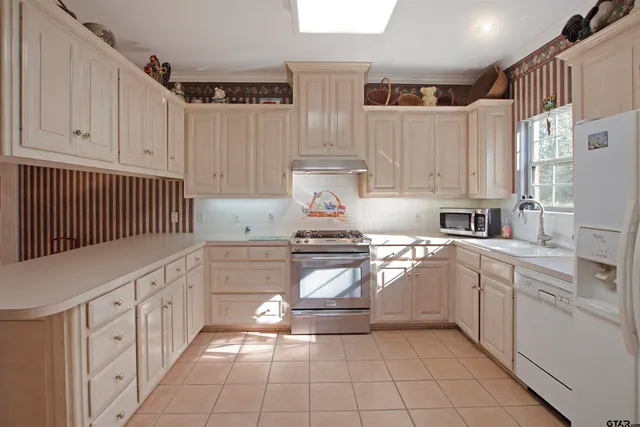 a kitchen with stainless steel appliances granite countertop a sink and cabinets