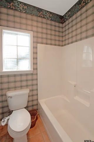 a white toilet sitting next to a bath tub