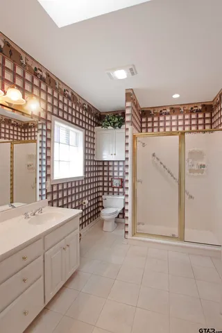 a bathroom with a double vanity sink mirror and toilet