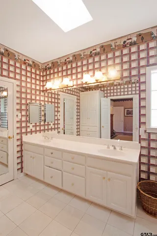 a bathroom with a double vanity sink a mirror and a bathtub