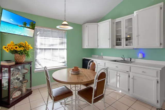 a kitchen with a dining table chairs and cabinets