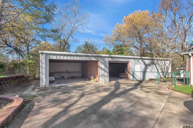 a view of house with yard and trees in the background