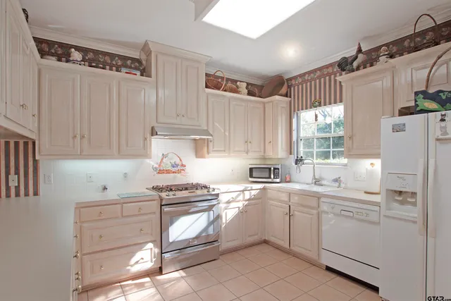 a kitchen with white cabinets and white appliances