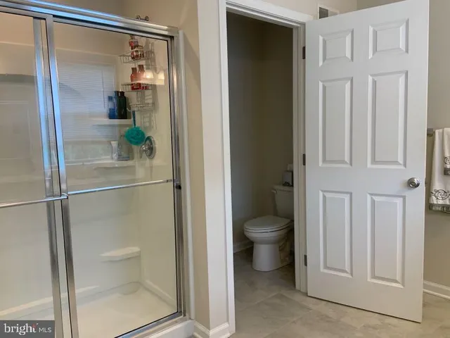 a bathroom with a granite countertop shower and a toilet