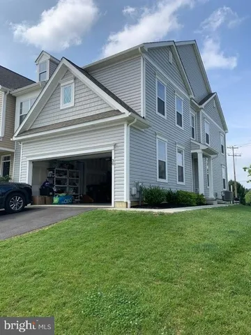 a front view of a house with a garden and trees
