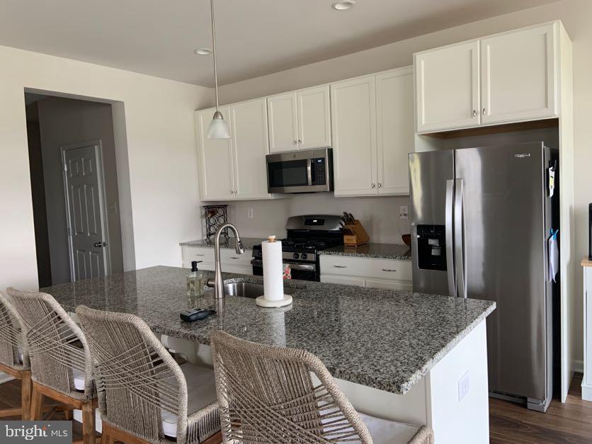 30 South Tompkins Square Downingtown, PA 19335 - Photo 8 of 33 a kitchen with stainless steel appliances granite countertop a refrigerator a stove a sink a dining table and chairs