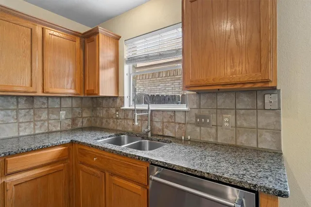 a kitchen with granite countertop a sink and cabinets