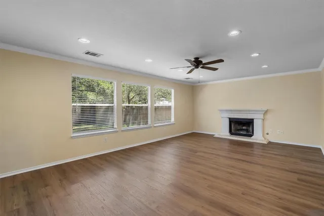 a view of an empty room with a fireplace and a window