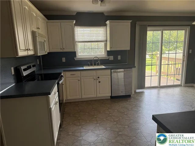 a kitchen with stainless steel appliances granite countertop a sink stove and cabinets