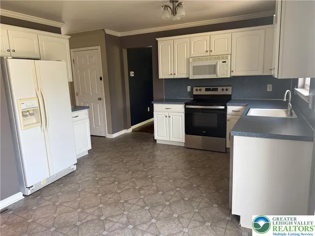 a kitchen with a refrigerator and a stove top oven