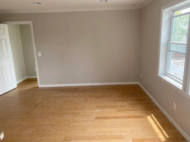a view of a room with wooden floor and a window