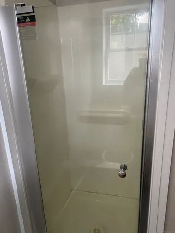 a view of a refrigerator in kitchen and an empty room