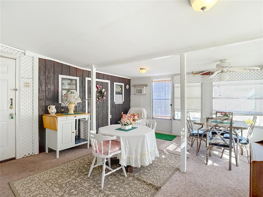 1646 Cockleshell Drive Holiday, FL 34690 - Photo 28 of 36 a living room with furniture and a dining table with floor to ceiling window