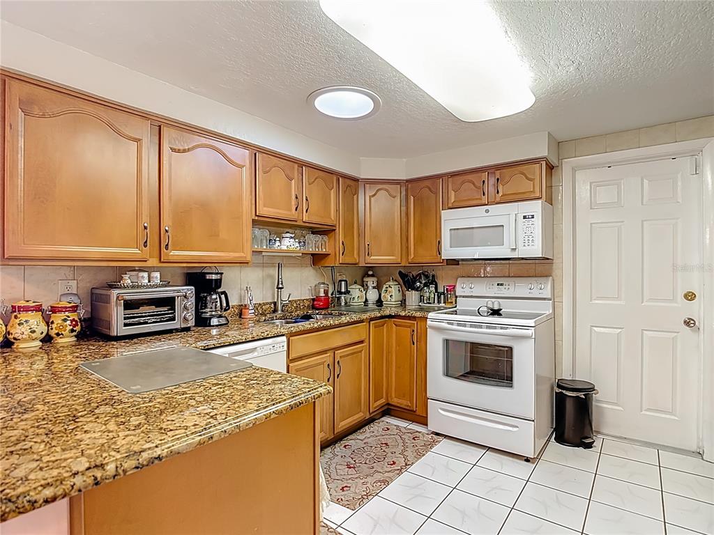 1646 Cockleshell Drive Holiday, FL 34690 - Photo 10 of 36 a kitchen with stainless steel appliances granite countertop a stove top oven a sink a counter top space and cabinets