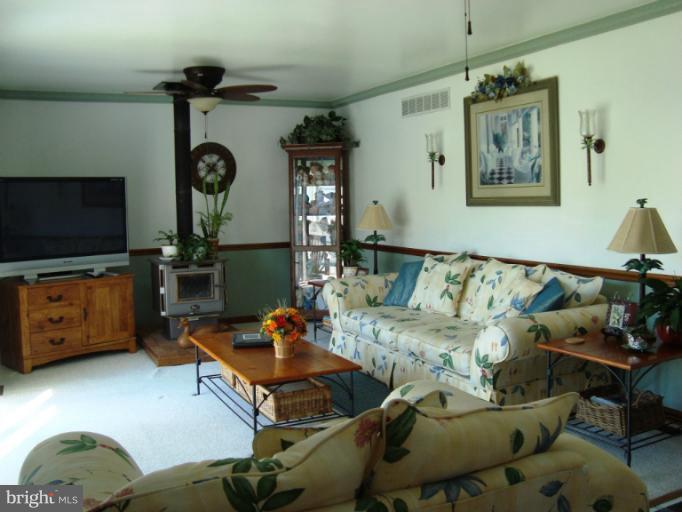 8166 N Road Severn, MD 21144 - Photo 11 of 25 a living room with furniture and a flat screen tv