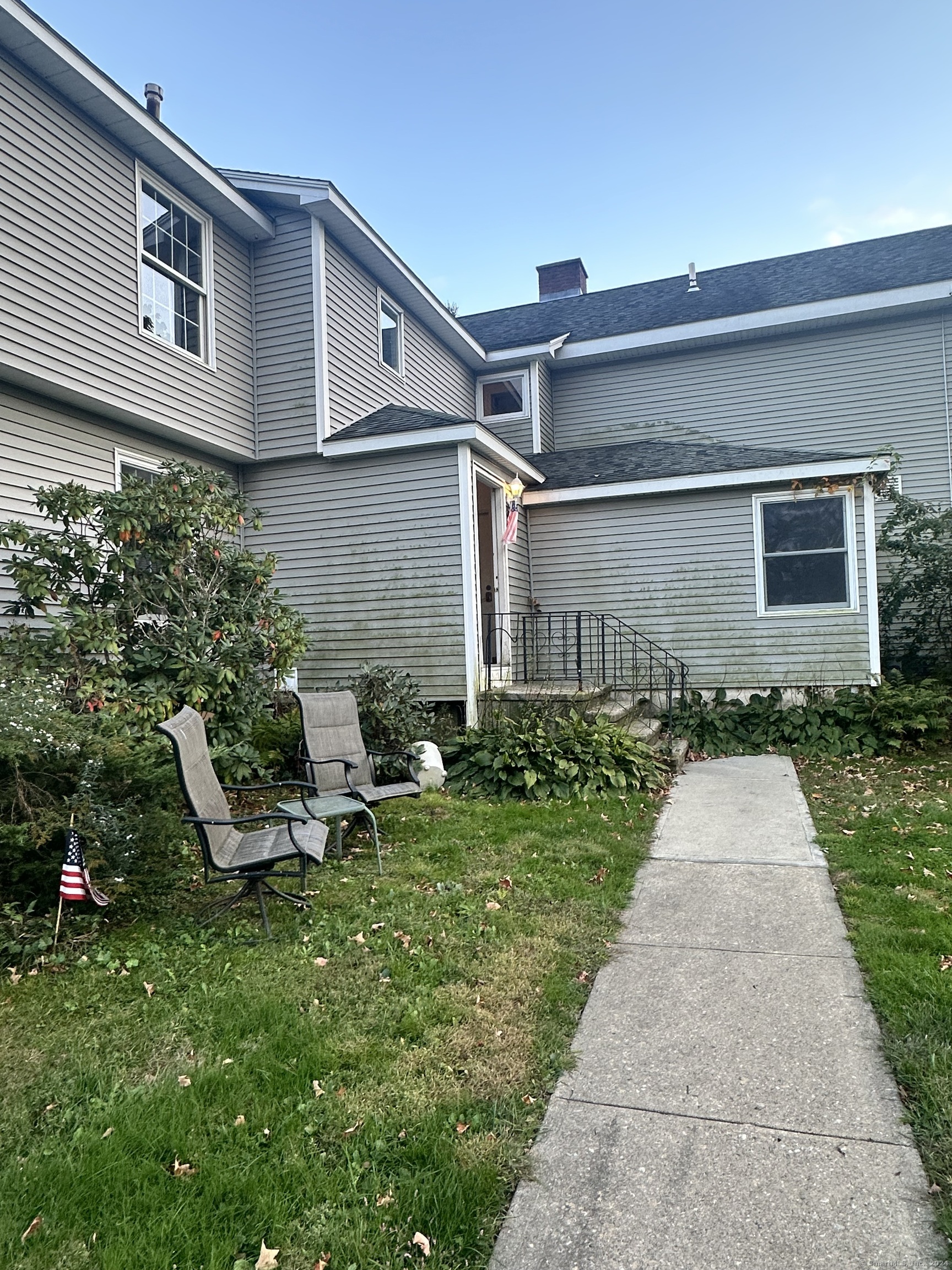 a front view of a house with a yard and outdoor seating