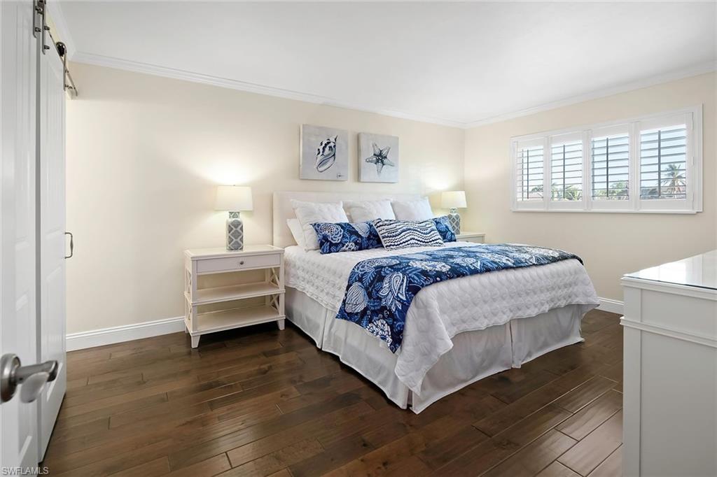 4160 Crayton Road, Unit A5 Naples, FL 34103 - Photo 12 of 46 Luxurious king-sized primary bedroom overlooking the lake