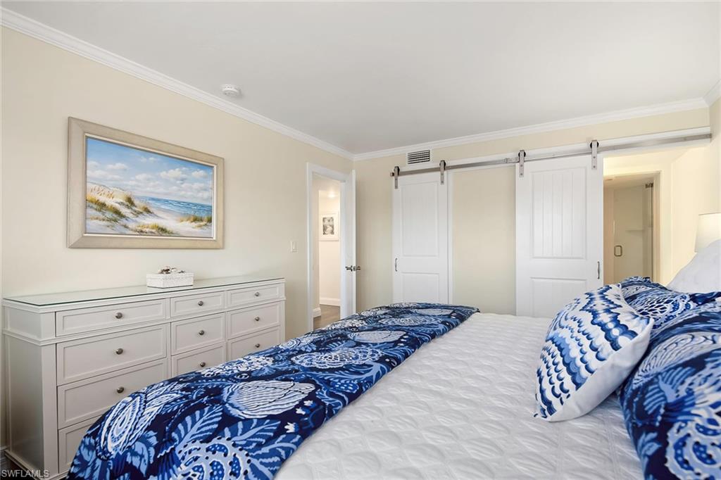4160 Crayton Road, Unit A5 Naples, FL 34103 - Photo 13 of 46 Barn doors open to a California walk in closet and remodeled bath