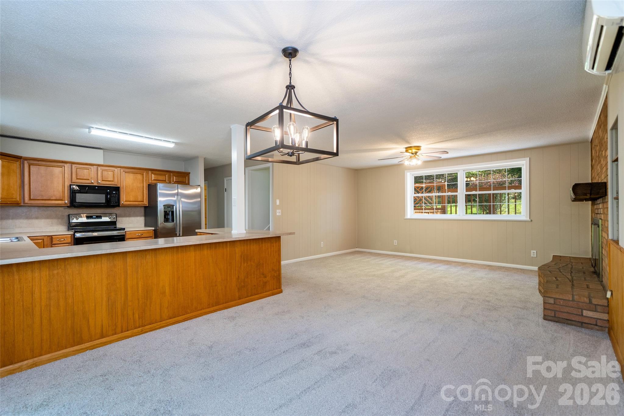 145 Jeter Mountain Road Hendersonville, NC 28739 - Photo 7 of 13 a view of a kitchen with kitchen island a sink wooden floor and living room view