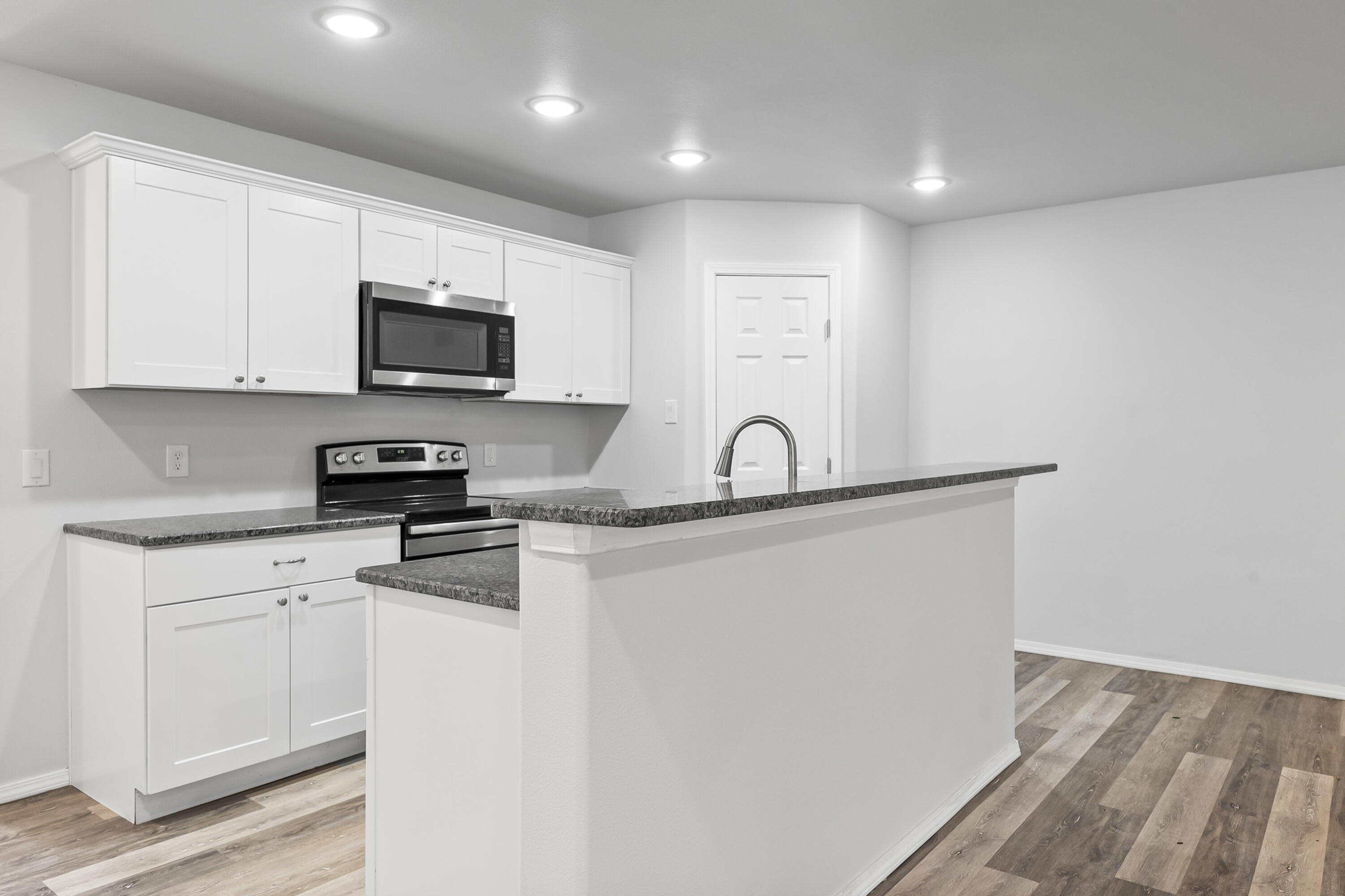 5609 Jarvis Street, Unit B Lubbock, TX 79416 - Photo 12 of 24 a kitchen with stainless steel appliances granite countertop a stove a sink and a microwave