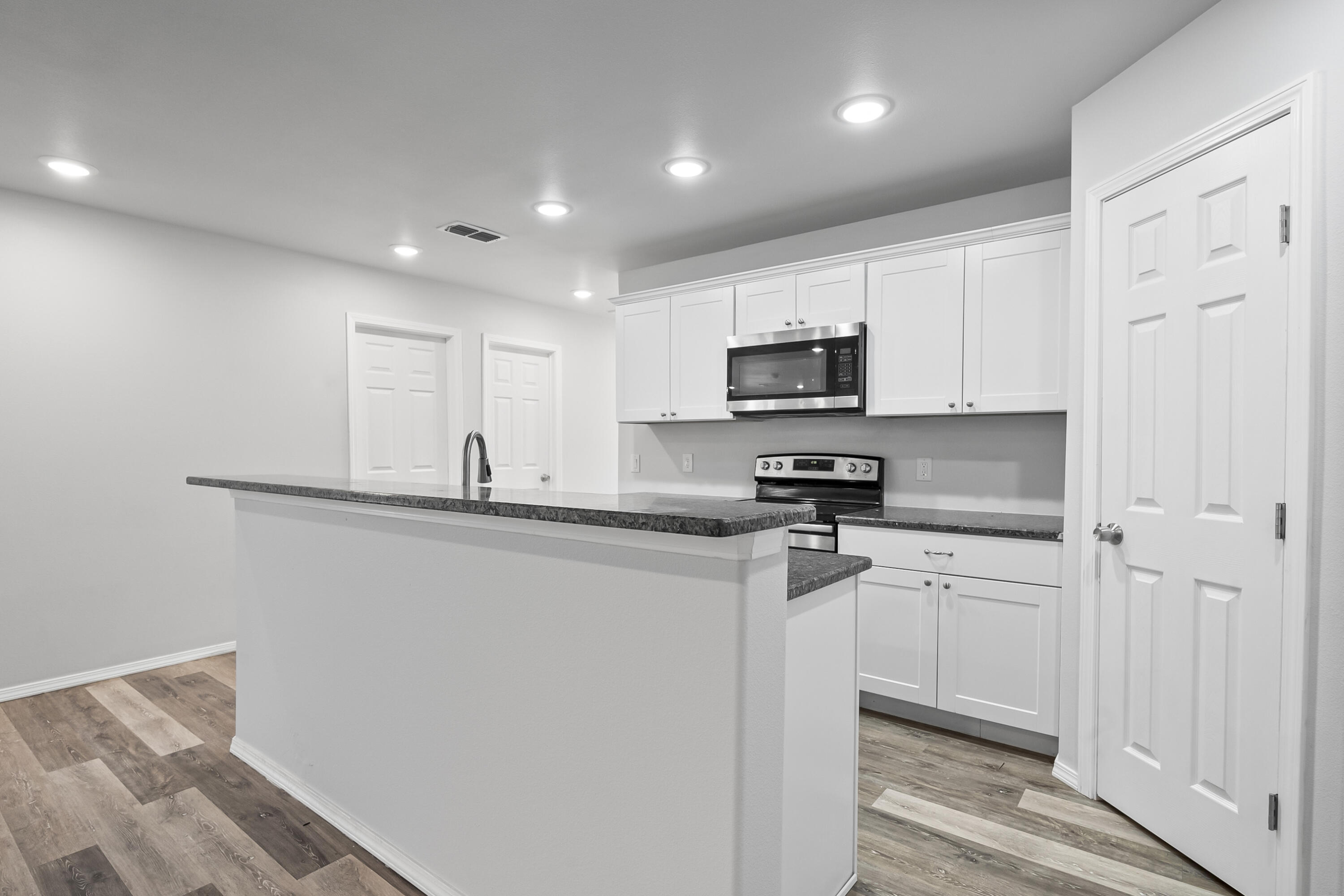 5609 Jarvis Street, Unit B Lubbock, TX 79416 - Photo 10 of 24 a kitchen with stainless steel appliances granite countertop a refrigerator and a stove top oven