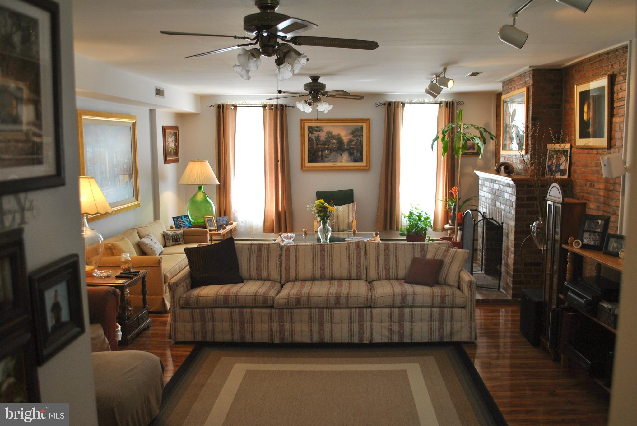 a living room with furniture ceiling fan and a rug