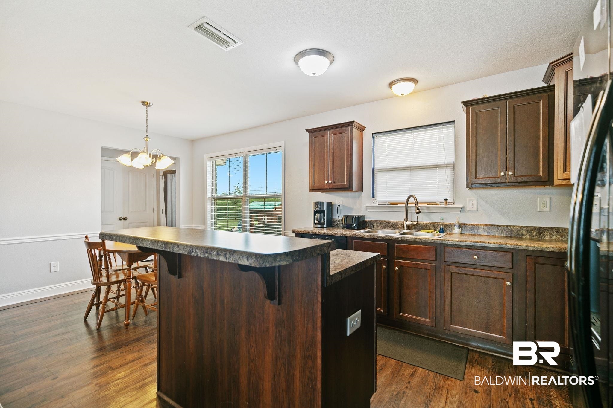 15573 Talus Court Foley, AL 36535 - Photo 14 of 50 Kitchen with dark hardwood / wood-style floors, a breakfast bar area, a center island, and sink