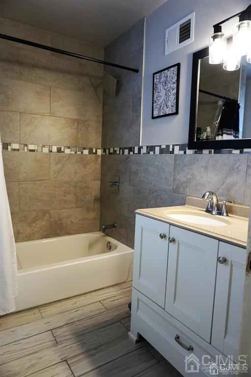 559 Johnstone Street Perth Amboy, NJ 08861 - Photo 14 of 24 a bathroom with a tub a sink and a shower