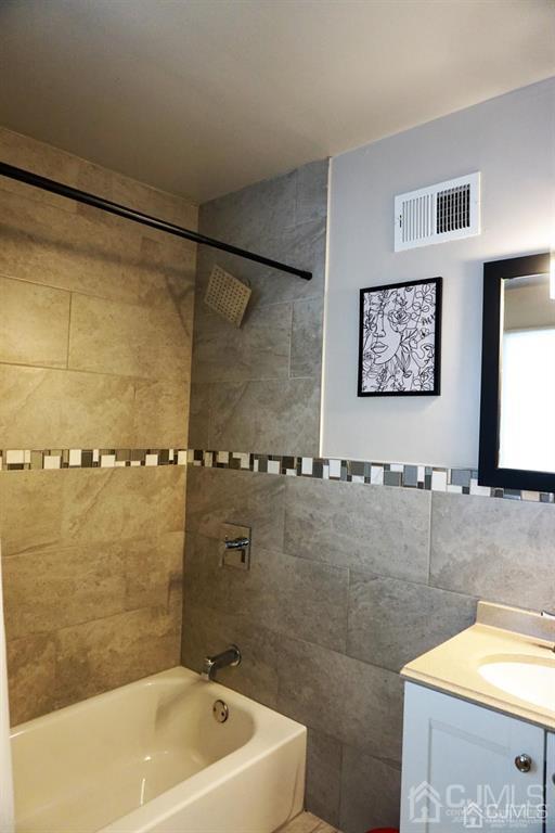 559 Johnstone Street Perth Amboy, NJ 08861 - Photo 15 of 24 a bathroom with a sink mirror and a bathtub