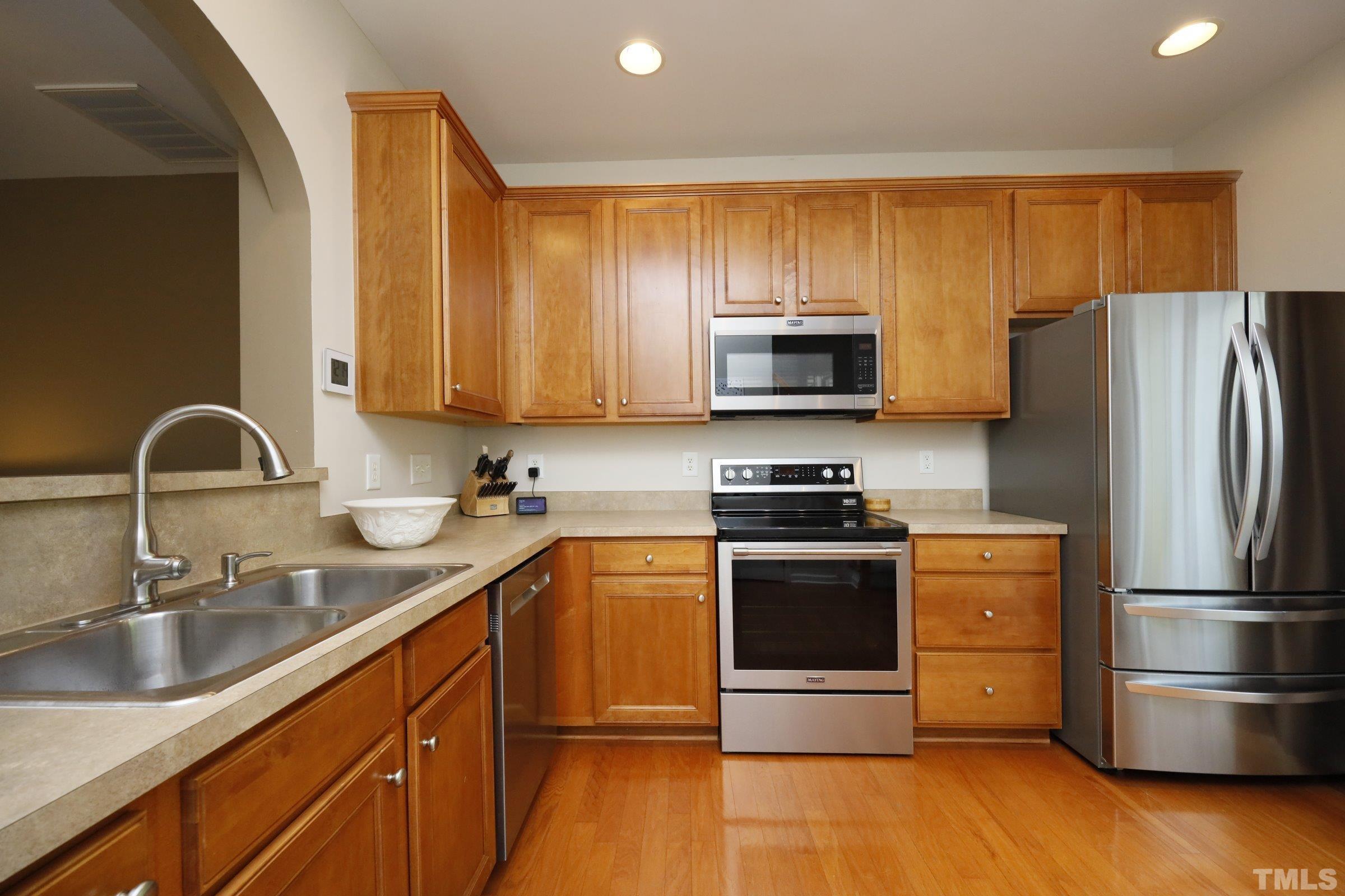 304 Red Elm Drive Durham, NC 27713 - Photo 11 of 27 a kitchen with stainless steel appliances granite countertop a sink stove and refrigerator