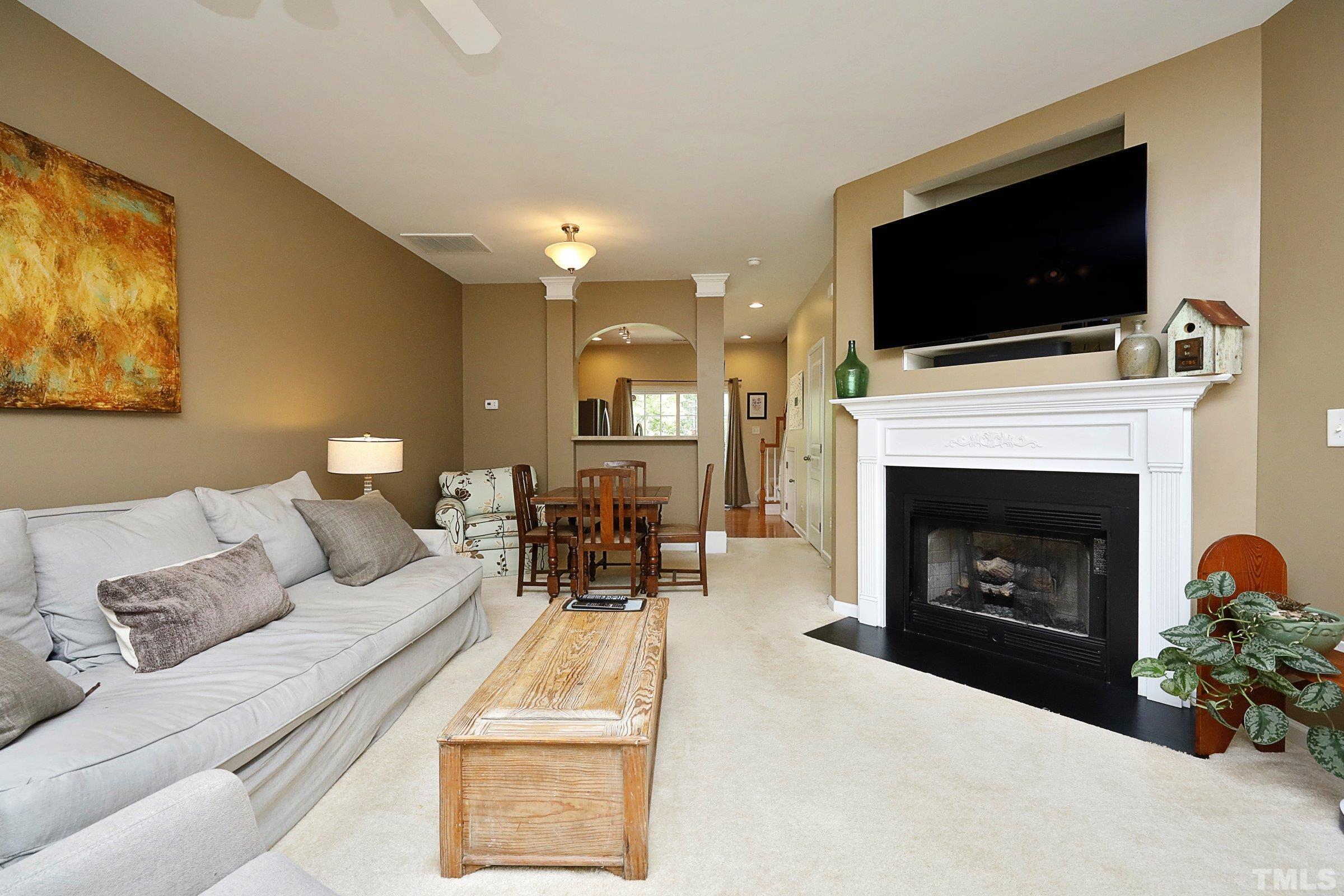 304 Red Elm Drive Durham, NC 27713 - Photo 5 of 27 a living room with furniture a fireplace and a flat screen tv