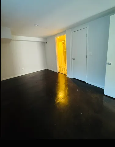 a view of empty room with a window and wooden floor