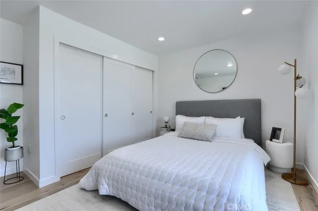 a bedroom with a bed and large windows