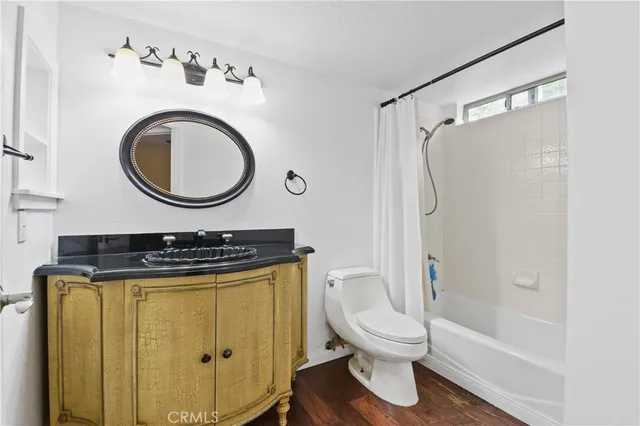 a bathroom with a granite countertop sink toilet and a mirror