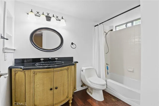 a bathroom with a granite countertop sink toilet and a mirror