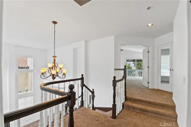 a view of a hallway with furniture and chandelier