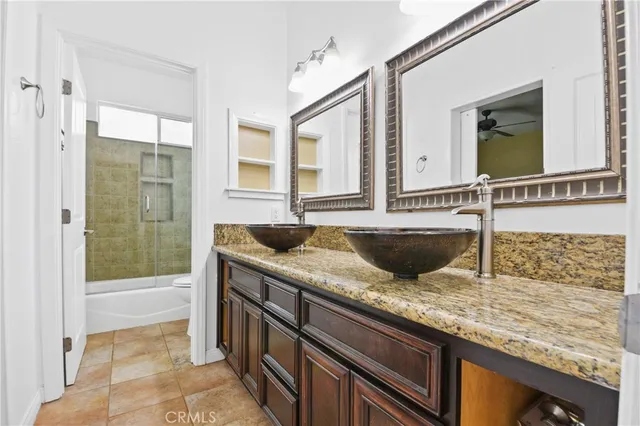 a bathroom with a granite countertop sink and mirror