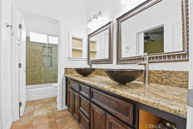 a bathroom with a granite countertop sink and mirror