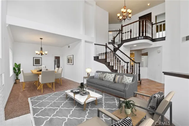 a living room with furniture chandelier and a table