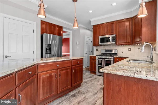 a kitchen with stainless steel appliances granite countertop a stove top oven microwave and cabinets