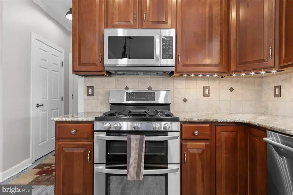 a kitchen with stainless steel appliances granite countertop a sink stove and refrigerator