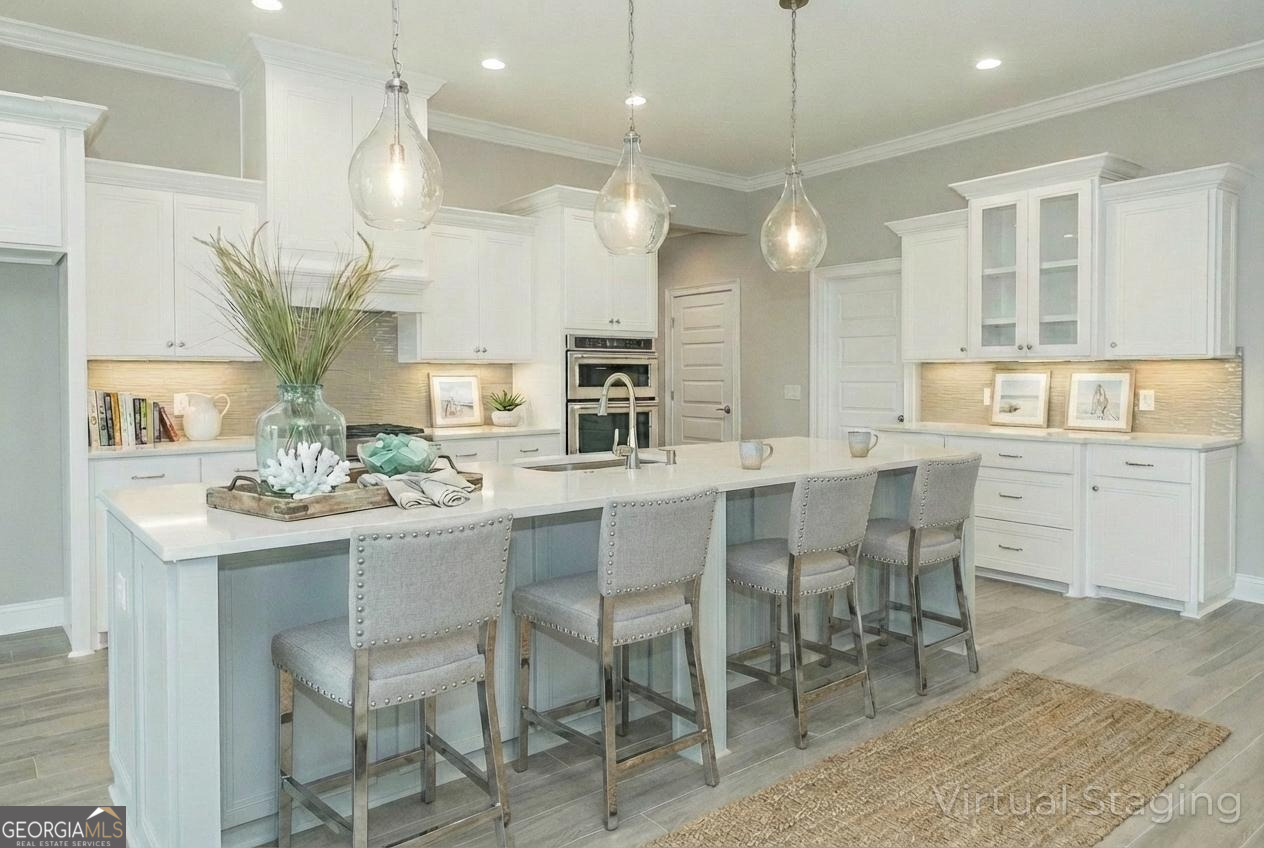 205 Riley Hunter Drive Kingsland, GA 31548 - Photo 5 of 81 a kitchen with stainless steel appliances kitchen island granite countertop a table and chairs in it