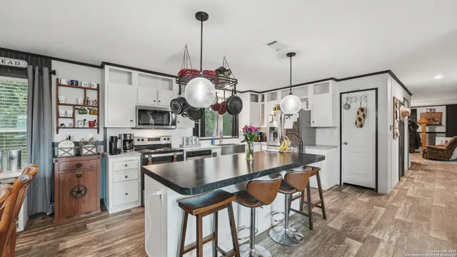 a kitchen with stainless steel appliances granite countertop a sink a stove and a refrigerator