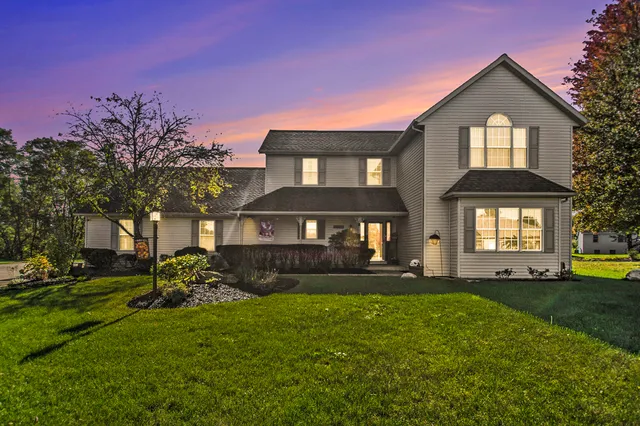 a front view of a house with a yard and trees