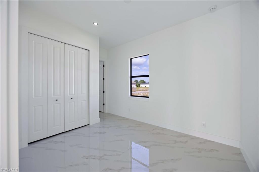 2700 49th Street Southwest Lehigh Acres, FL 33976 - Photo 17 of 24 Unfurnished bedroom with light marble finish flooring, a closet, and recessed lighting