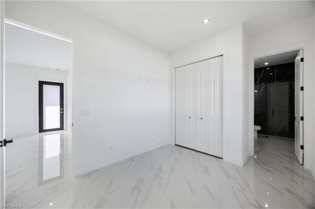 2700 49th Street Southwest Lehigh Acres, FL 33976 - Photo 18 of 24 Unfurnished bedroom featuring light marble finish flooring, recessed lighting, a closet, and connected bathroom