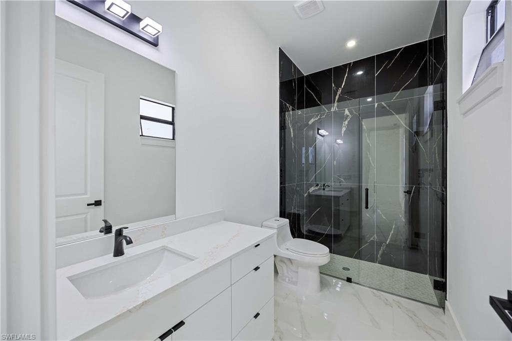 2700 49th Street Southwest Lehigh Acres, FL 33976 - Photo 19 of 24 Full bath with vanity, a marble finish shower, recessed lighting, and light marble finish floors
