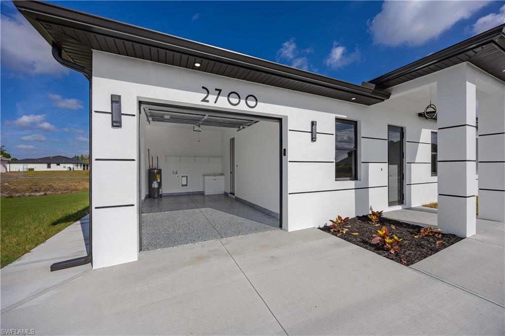 2700 49th Street Southwest Lehigh Acres, FL 33976 - Photo 4 of 24 Garage featuring water heater