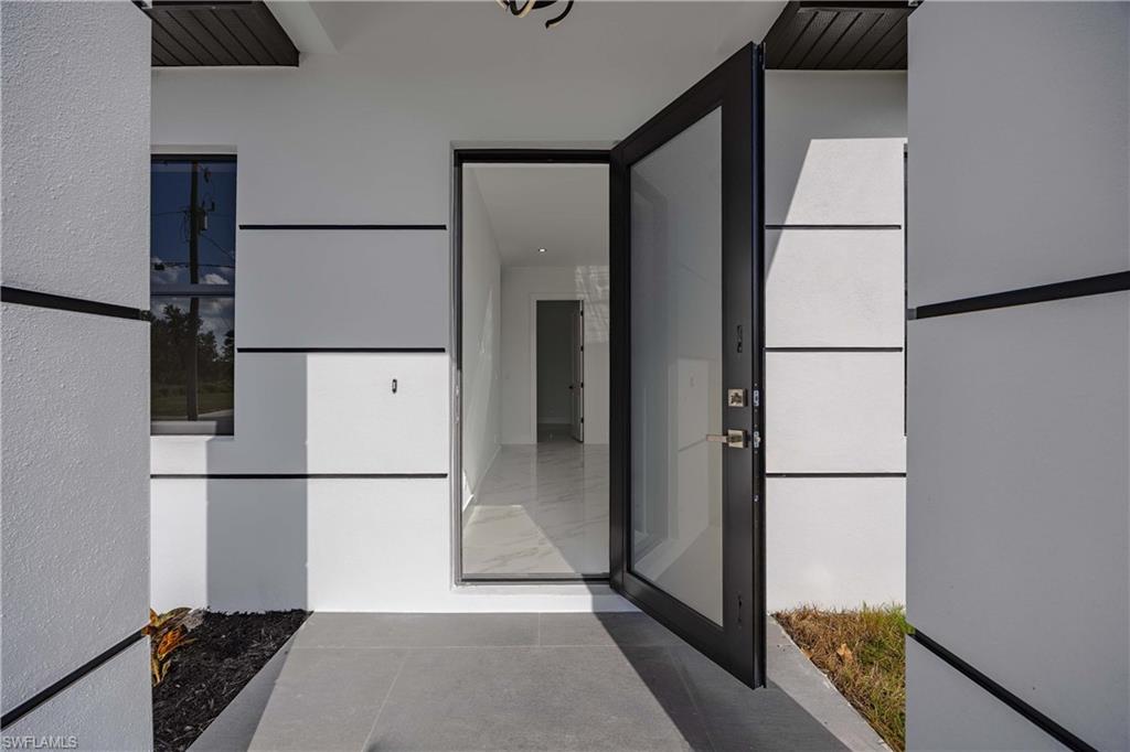 2700 49th Street Southwest Lehigh Acres, FL 33976 - Photo 6 of 24 Entrance to property featuring stucco siding