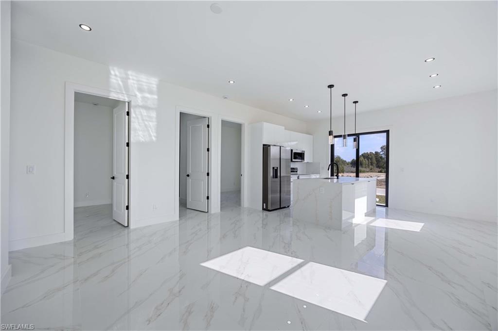 2700 49th Street Southwest Lehigh Acres, FL 33976 - Photo 9 of 24 Unfurnished living room featuring recessed lighting and light marble finish flooring
